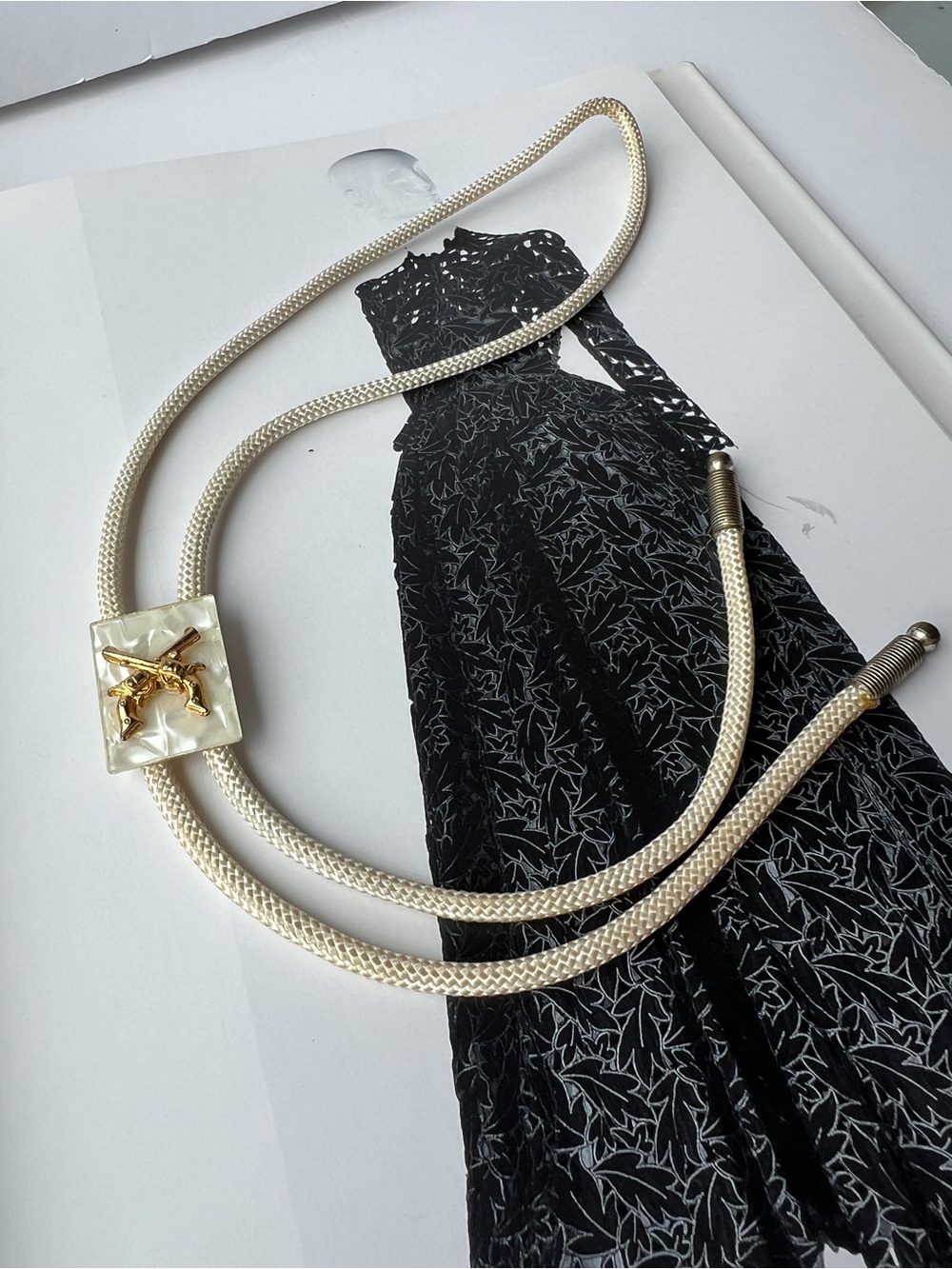 Ivory Rope Bolo Tie with Revolvers centered on Faux Mother-of-Pearl
